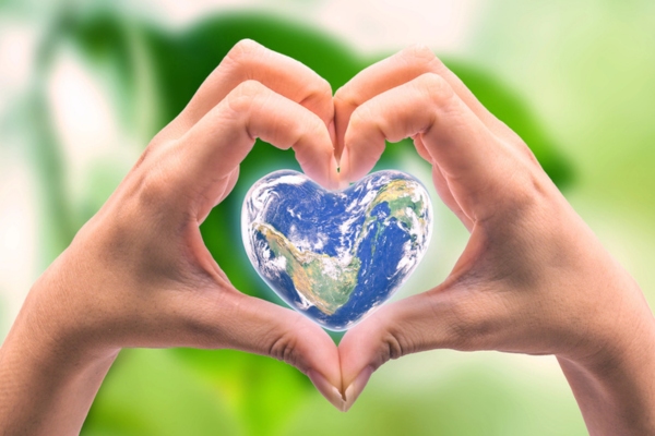 hand and earth shaped as heart depicting Propane as Greener Energy Option