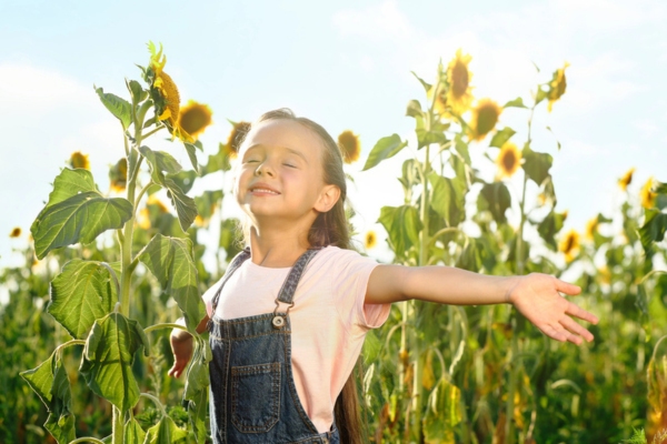little girl smiling near sunflowers depicting propane cleaner combustion