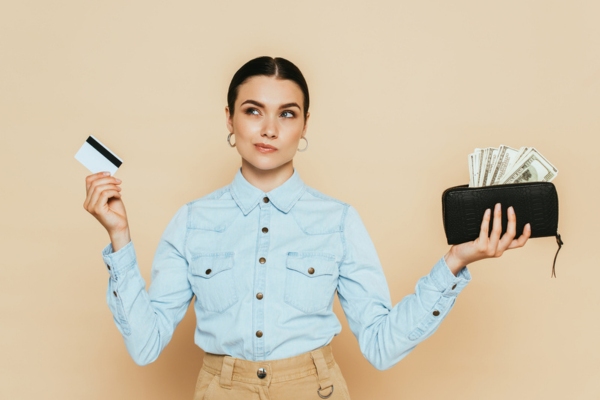 woman holding card and a wallet with cash on each hand depicting Payment Options