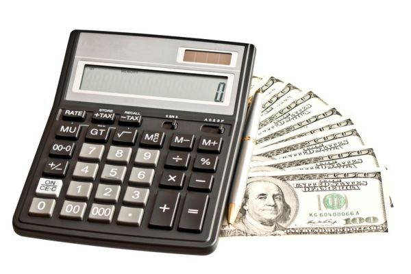 calculator and pen on top of dollar bills depicting Cost and Maintenance Considerations