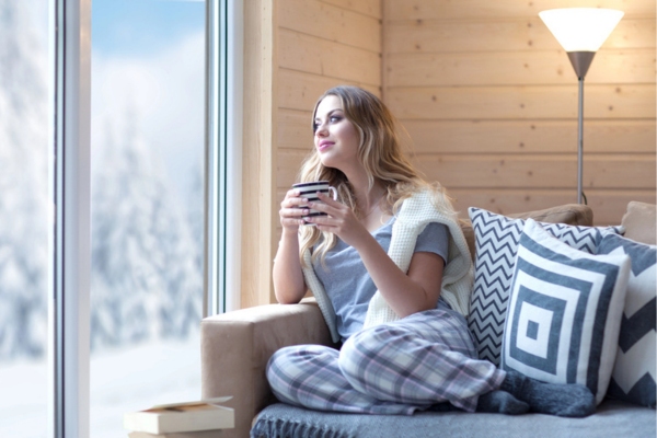 woman lounging at home by the couch depicting home comfort