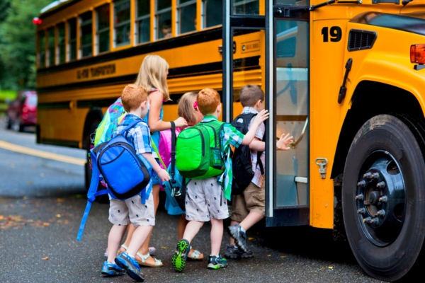 kids lined up to ride a school bus