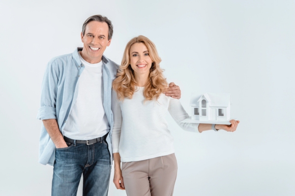 Couple with house model depicting homeowners
