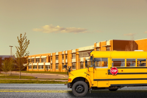 image of a school bus by a school building