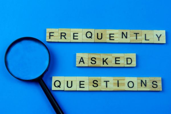 Frequently Asked Questions spelled using wooden letter chips depicting Bus Fleet Fueling FAQs
