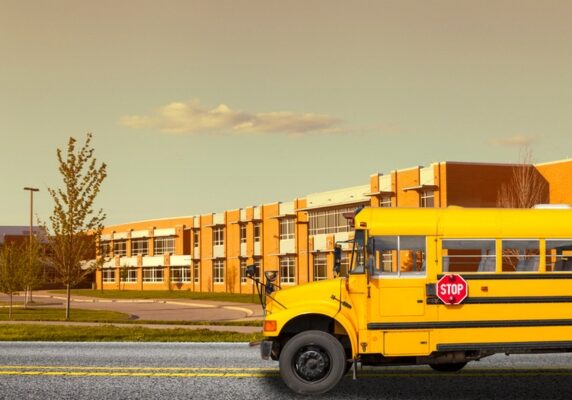 image of a school bus by a school building
